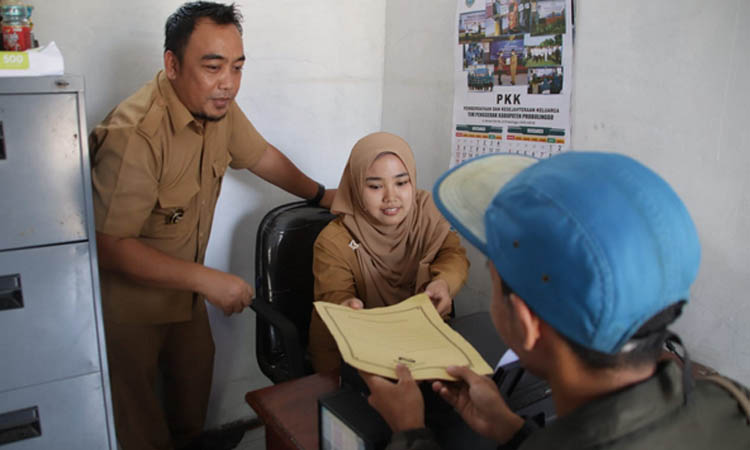 BERHADAPAN WARGA: Perangkat Desa Tanjungsari, Kecamatan Krejengan memberikan pelayanan terhadap warga. Dalam UU terbaru, SK pengangkatan perangkat desa akan dite
