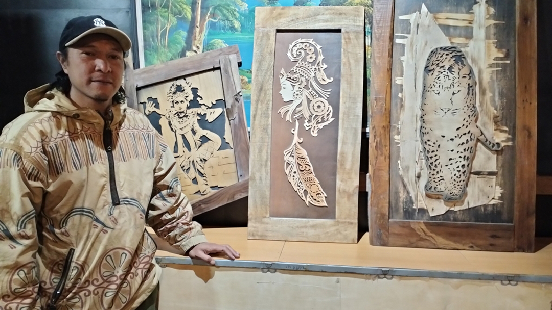 DARI LIMBAH: Firman Arif, 41, seniman lukisan kayu asal Kecamatan Tosari, Kabupaten Pasuruan di depan karya lukisnya yang terbuat dari limbah kayu.