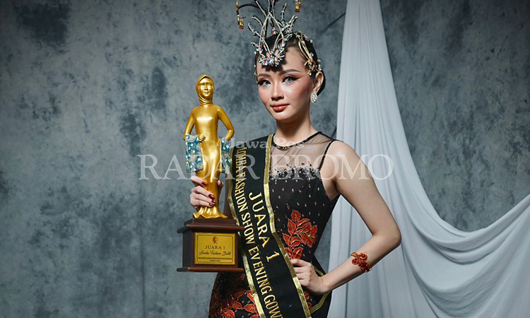 JAWARA: Feby Andriani, 23, berpose dengan pialanya setelah meraih juara pertama dalam lomba fashion batik memperingati pekan batik daerah yang digelar Pemkab Bojonegoro.
