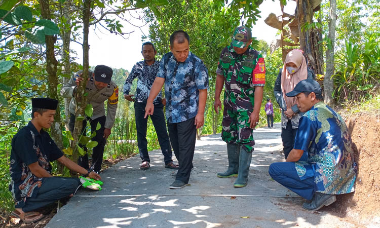 KOKOH: Camat Krucil Febrya Ilham Hidayat (tengah) saat mengecek jalan rabat beton menuju wisata air terjun di Dusun Jaran Goyang.