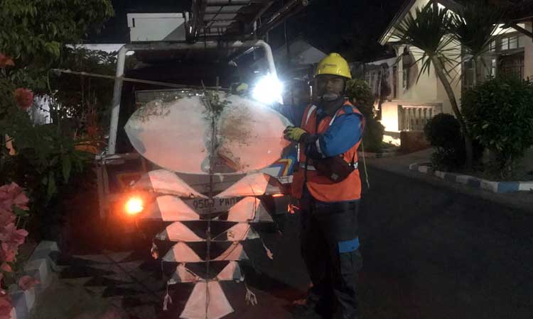 BIANG KELADI: Petugas PLN menunjukkan layang-layang suwangan yang nyangkut di kabel PLN Jalan Juanda hingga menyebabkan listrik padam, Senin petang (15/7). (Vikry Romadhoni/ Radar Bromo)