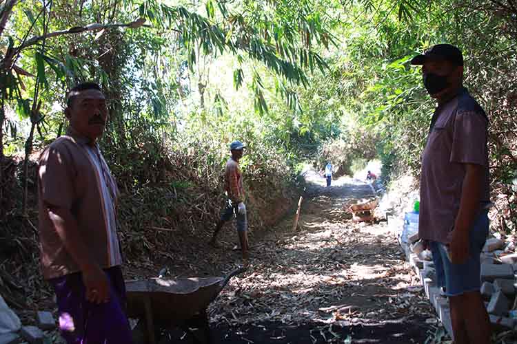 PANTAU LANGSUNG: Kades Sepuh Gembol Kusnadi mengawasi langsung pengerjaan pembangunan jalan paving sepanjang 340 meter di Dusun Sak-sak.