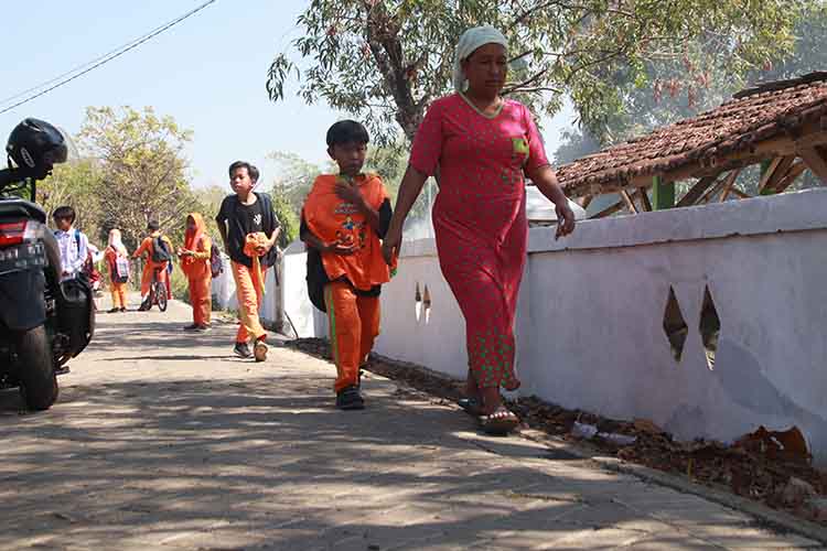 LEBIH BAIK: Sejumlah pelajar melintas di Jalan Dusun Kosong, yang semakin nyaman dilintasi setelah diperbaiki. Jalan sepanjang 550 meter ini telah dipaving.