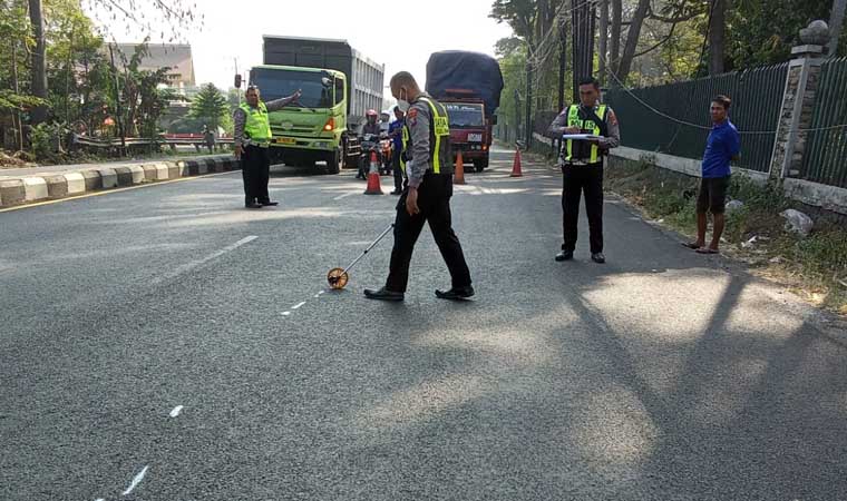 OLAH TKP: Petugas Satlantas Polres Pasuruan saat melakukan olah TKP kecelakaan yang menewaskan seorang penumpang motor.