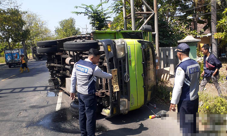 EVAKUASI: Truk yang terguling di Jalan Raya Ir H Juanda, Kelurahan Blandongan, Kecamatan Bugul Kidul. Kecelakaan tunggal itu, diduga lantaran as roda patah.