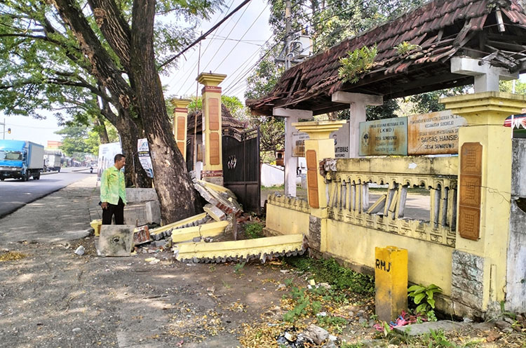 ROBOH: Pagar Balai Desa Suwayuwo, roboh diduga disebabkan akar pohon yang terus membesar.