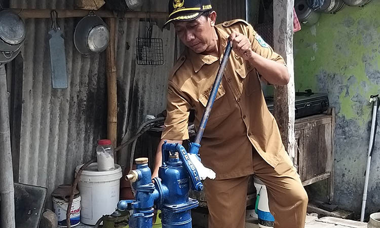 LANCAR: Perangkat Desa Penambangan Samsul Hadi mencoba sumur bor yang dibangun Pemerintah Desa Penambangan di Dusun Gilin.