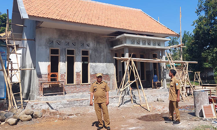 AWASI LANGSUNG: Kepala Desa Tunggak Cerme Musta&rsquo;in mengawasi pengerjaan pembangunan gedung sanggar dan ruang pertemuan yang sudah mencapai 80 persen.