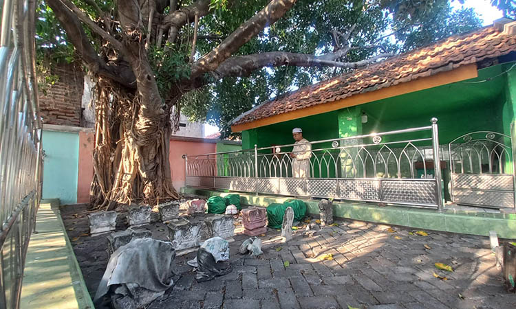 SAKRAL: Pendiri Haul Akbar Bujuk Macan Laut, Muhammad Khoirul Anam sedang berdoa di makam Mbah Bujuk Macan Laut, Jalan Ikan Tengiri, Kecamatan Mayangan, Kota Probolinggo.