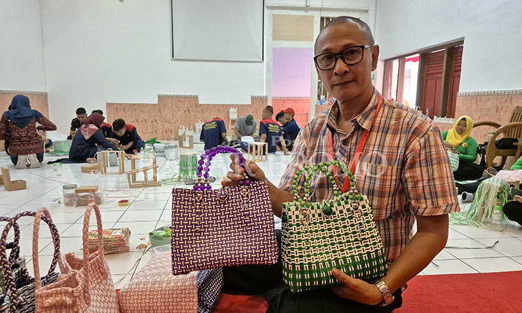 DISUKAI: Instruktur pembuat tas anyaman berbahan jali, Yudiansyah, menunjukkan tas buatan warga binaan Lapas IIB Pasuruan.