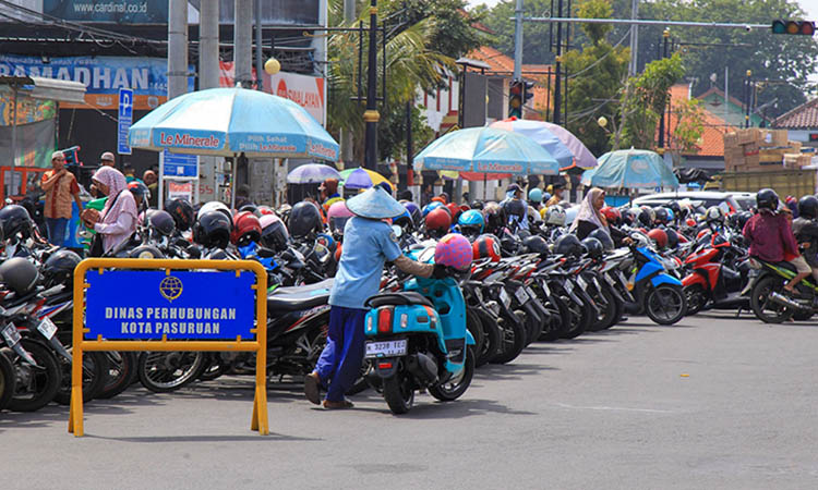 DITATA: Salah satu juru parkir di Kota Pasuruan saat tengah menata motor pengunjung. Meski tampak ramai, ada indikasi kalau potensi pendapatan dari parkir di Kota Pasuruan, bocor.