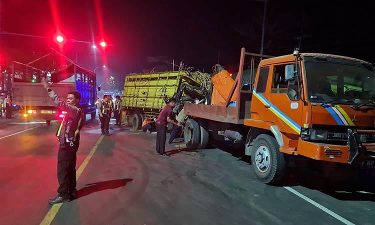 MACET: Petugas Satlantas Polres Pasuruan Kota saat mengatur arus lalu lintas yang macet, imbas dua truk adu moncong.