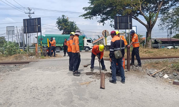 ANTISIPASI: Petugas memasang tiang di perlintasan sebidang Desa Pesisir, Sumberasih, untuk mempersempit lintasan dengan tujuan pengendara yang lewat lebih ha