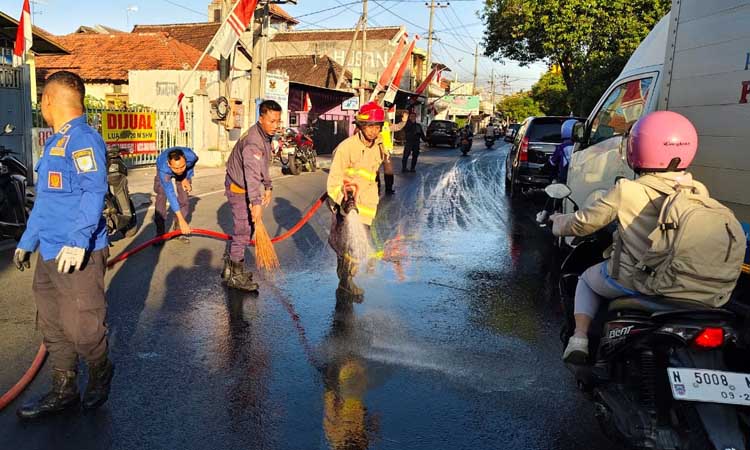Petugas Damakr saat membersihkan ceceran solar di jalan Pahlawan, Kota Probolinggo, Kamis pagi (15/8).