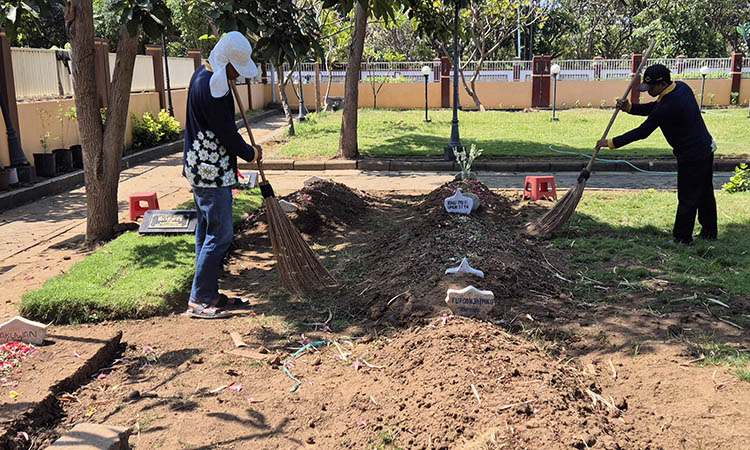 BERSIHKAN: Petugas makam membersihkan areal makam di TPU Purut III. Saat ini peminat TPU baru ini semakin banyak. Ada 10 makam.