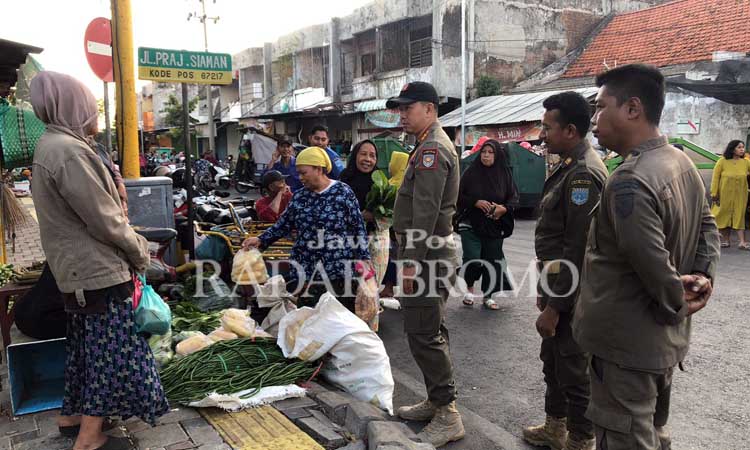 Kabid Trantibum Satpol PP Kota Probolinggo Abdi Firdausi bersama petugas Satpol PP memberikan sosialisasi pada pedagang liar di Pasar Baru, Selasa (20/8). (Inneke Agustin/ Radar Bromo)