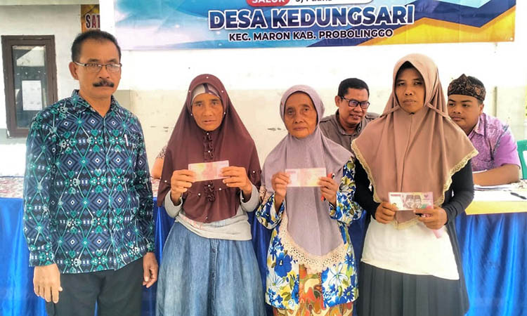 SALURKAN: Kepala Desa Kedungsari Mahfud (paling kiri) saat menyalurkan BLT-DD kepada keluarga penerima manfaat.
