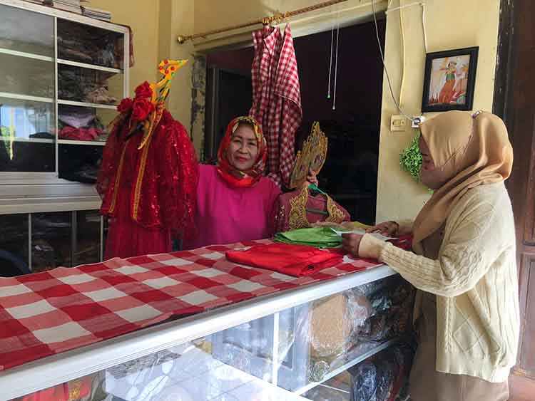 PELANGGAN: Haryuni, warga Kelurahan Ketapang, Kecamatan Kademangan, Kota Probolinggo, melayani penyewaan baju adat, Senin (26/8).