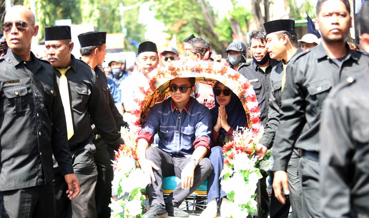 DIANTAR PENDUKUNG: Zulmi Noor Hasan bersama istrinya menaiki becak ketika mendaftar ke KPU, Selasa (27/8). Abd Rasit pasangannya juga sama.