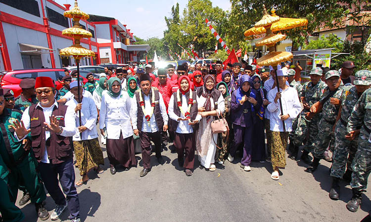 DIDAMPINGI PENDUKUNG: Bapaslon Gus Mujib-Ning Wardah tiba di kantor KPU Kabupaten Pasuruan yang berada di Bangil.