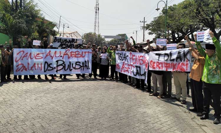 PROTES: Pemdes, BPD dan warga Desa Bulusari demo protes rencana pengalihan jalan desa jadi jalan kabupaten oleh Pemkab Pasuruan. (Rizal Syatori/ Radar Bromo)