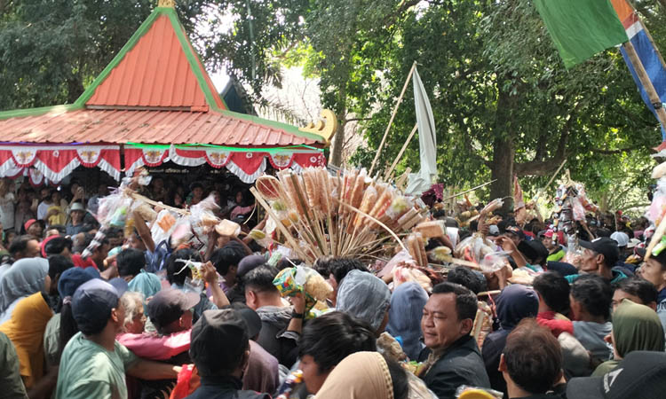 ANTUSIAS: Ratusan warga berebut isi ancak dalam kegiatan sedekah bumi Dusun Kesiman, Candi, dan Dusun Guci, Desa Sukoreno. (Rizal Syatori/Jawa Pos Radar Bromo)