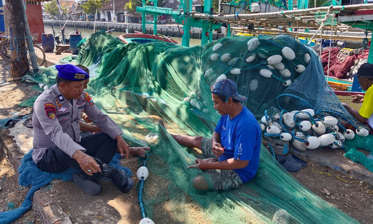 SOSIALISASI: Personel Polairud Polres Pasuruan memberi imbauan ke nelayan di pesisir Kota Pasuruan. Selama ombak tinggi, nelayan biasanya tak melaut.