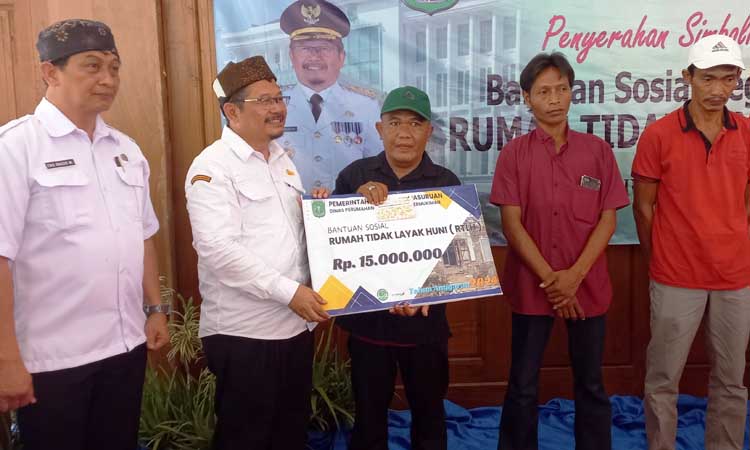 DISERAHKAN: Pj Bupati Pasuruan Andriyanto penyerahan simbolis bantuan sosial RTLH kepada penerima program di Kantor Kecamatan Grati.