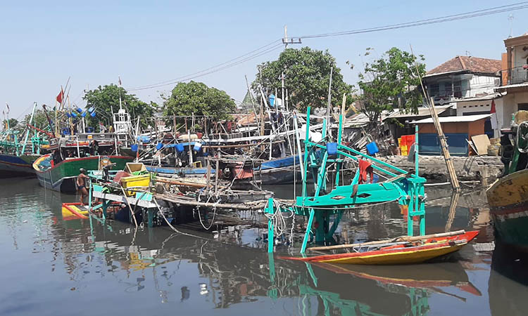 MANGKRAK: Bangkai perahu yang dibiarkan mengapung di Kali Gembong. Dampaknya, banyak kayu-kayu dari perahu tersebut yang berjatuhan ke sungai.
