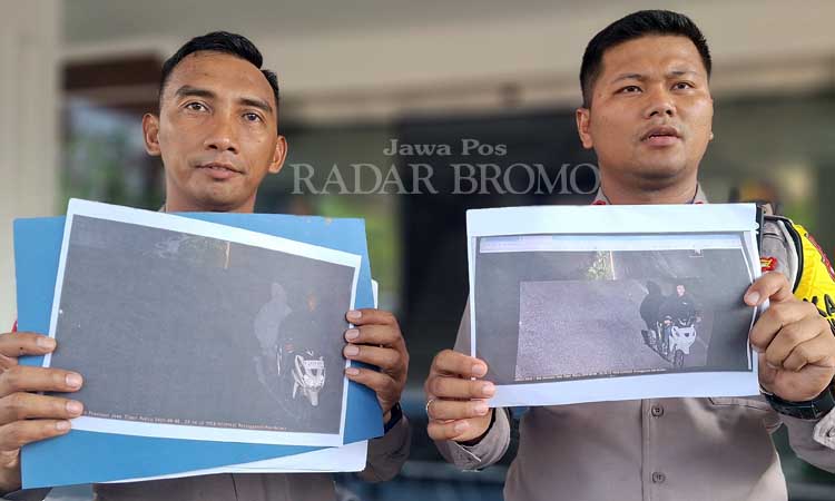 KLARIFIKASI: Petugas kepolisian menunjukkan tangkapan etle yang asli merekam pengendara kena tilang karena tak kenakan helm. Polisi pastikan yang dibonceng bukan pocong. (M Busthomi/ Radar Bromo)