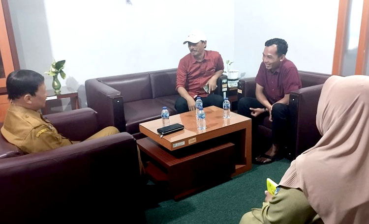 WADUL: M. Reza (kanan) didampingi Nasution (tengah) mengadu ke Disperin Naker Kota Probolinggo.