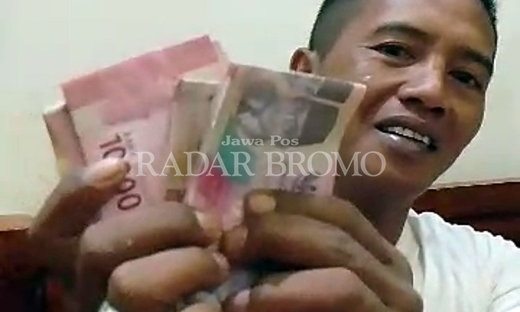 PAMER UANG: Kades Curahtemu Busairi memperlihatkan segepok uang yang disiapkan untuk memenangkan salah satu bakal paslon bupati - wakil bupati dalam pemilihan bupati (Pilbup) di Kabupaten Probolinggo.