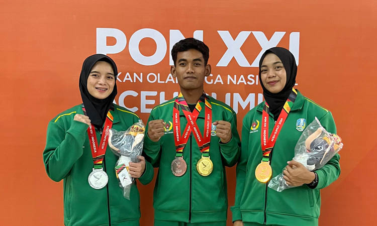 TRIO: Erfin Nofitarini, Dimas Lukito Wardhana dan Ikke Nurhayati memamerkan medali PON XXI.