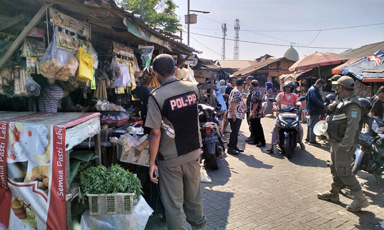 DITERTIBKAN: Petugas Pasar Pandaan bersama Satpol PP melakukan penertiban pedagang yang ada di area Pasar Pandaan.