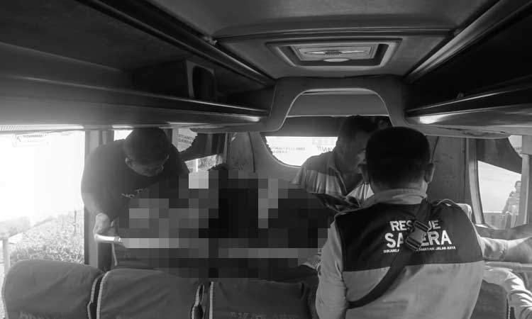 Petugas saat mengevakuasi korban yang meninggal di dalam bus.