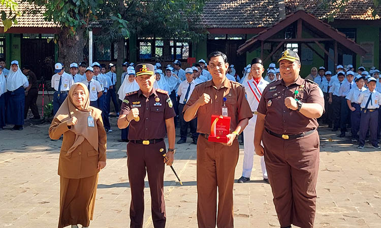SINERGI: Seusai menjadi inspektur upacara, Kajari Kota Probolinggo Dodik Hermawan foto bersama dengan Kepala Disdikbud Kota Probolinggo Siti Romlah dan seluruh siswa-siswi SMPN 8 Kota Probolinggo.