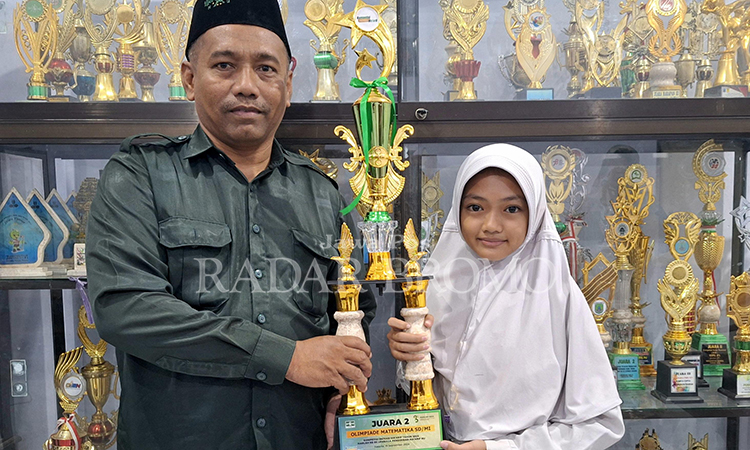 JUARA DUA: Alisha Naurella menunjukkan tropi Juara II Olimpiade Nasional Bidang Matematika yang digelar LP Maarif PBNU 2024.