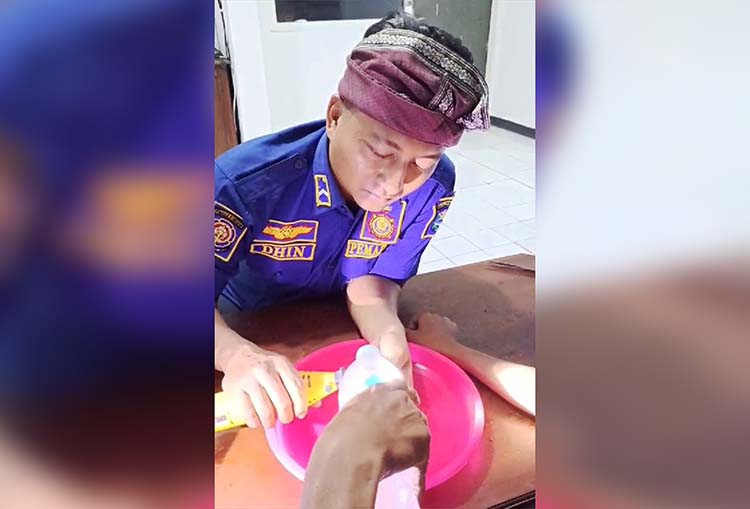 DILEPAS: Petugas Damkar berusaha melepas cincin di jari telunjuk MS dengan hati-hati.