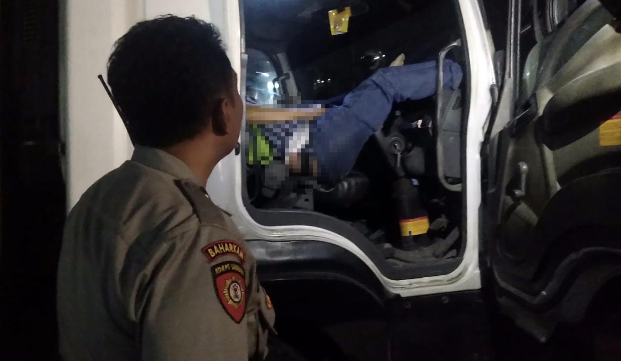 Petugas saat hendak mengevakuasi jenazah sopir yang meninggal di ruang kemudi truk.