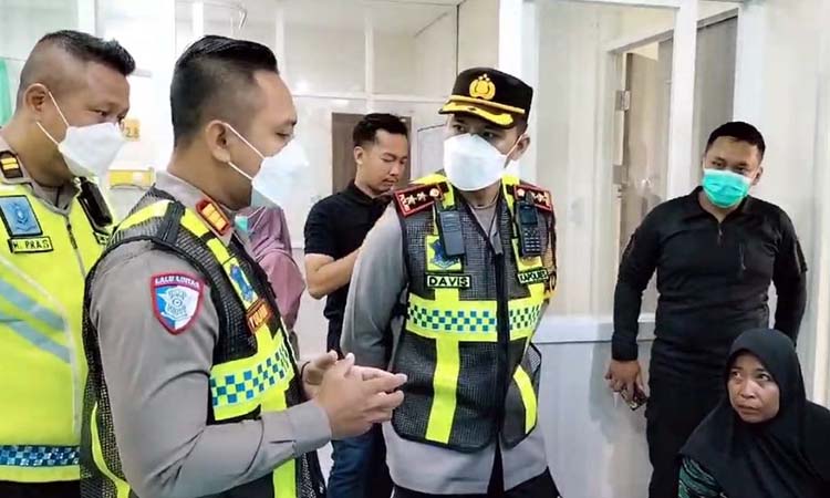 Petugas kepolisian saat menjenguk kondisi Lidia ( tak terlihat) yang jadi salah satu korban kecelakaan maut di Tol Paspro Grati. (Mokhamad Zubaidillah/ Radar Bromo)