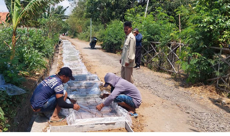 KONTROL PROYEK: Sekdes Patokan Soleh Hudin (bediri), meninjau langsung proses pembangunan drainase di Dusun Krajan. (Arif Mashudi/Jawa Pos Radar Bromo)