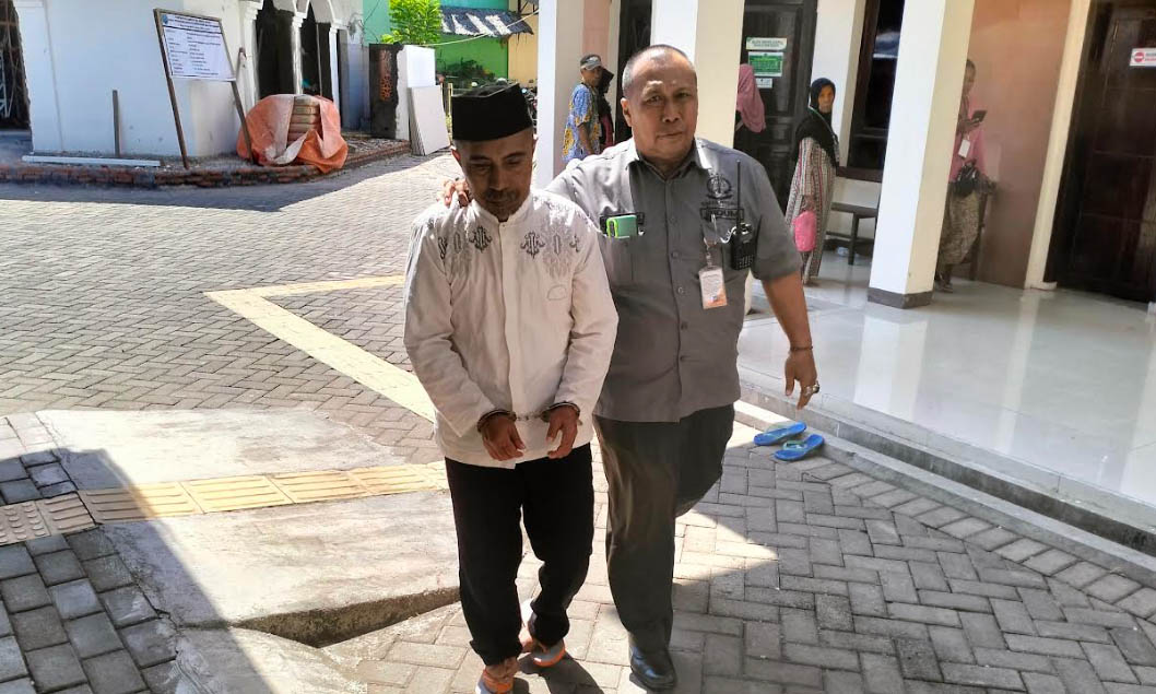 DIGIRING: Sl hendak memasuki ruang pesidangan di PN Kraksaan, Kamis (24/10).