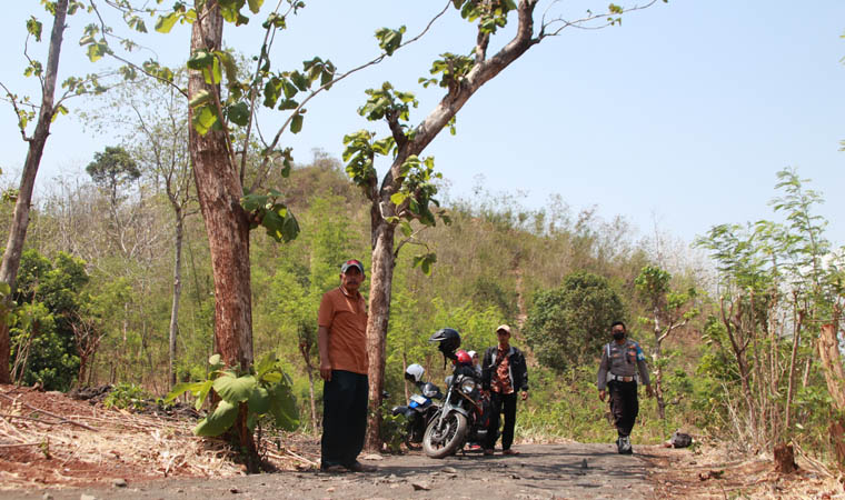 KIRI-KANAN: Kepala Desa Gunung Tugel, Asen; salah satu perangkat Desa Gunung Tugel, Asmuri; dan Bhabinkamtibmas Desa Gunung Tugel, Aipda Robby Patikana di lokasi pembangunan jalan makadam.