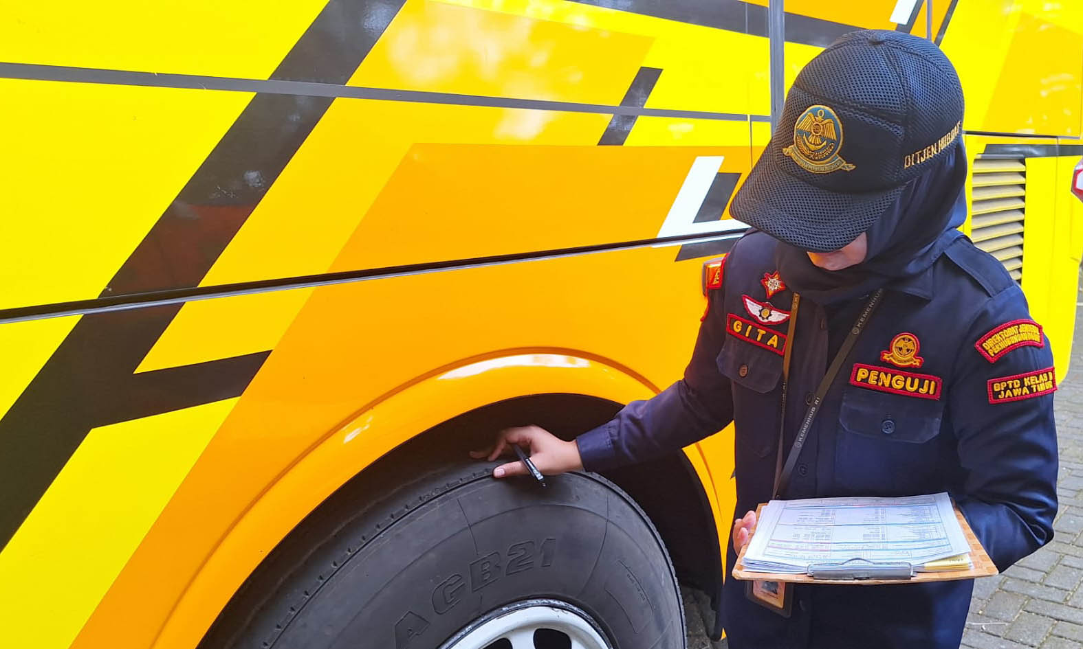 RAMPCHEK: Gaya Annisa Gita Komara saat mengecek kendaraan bus.