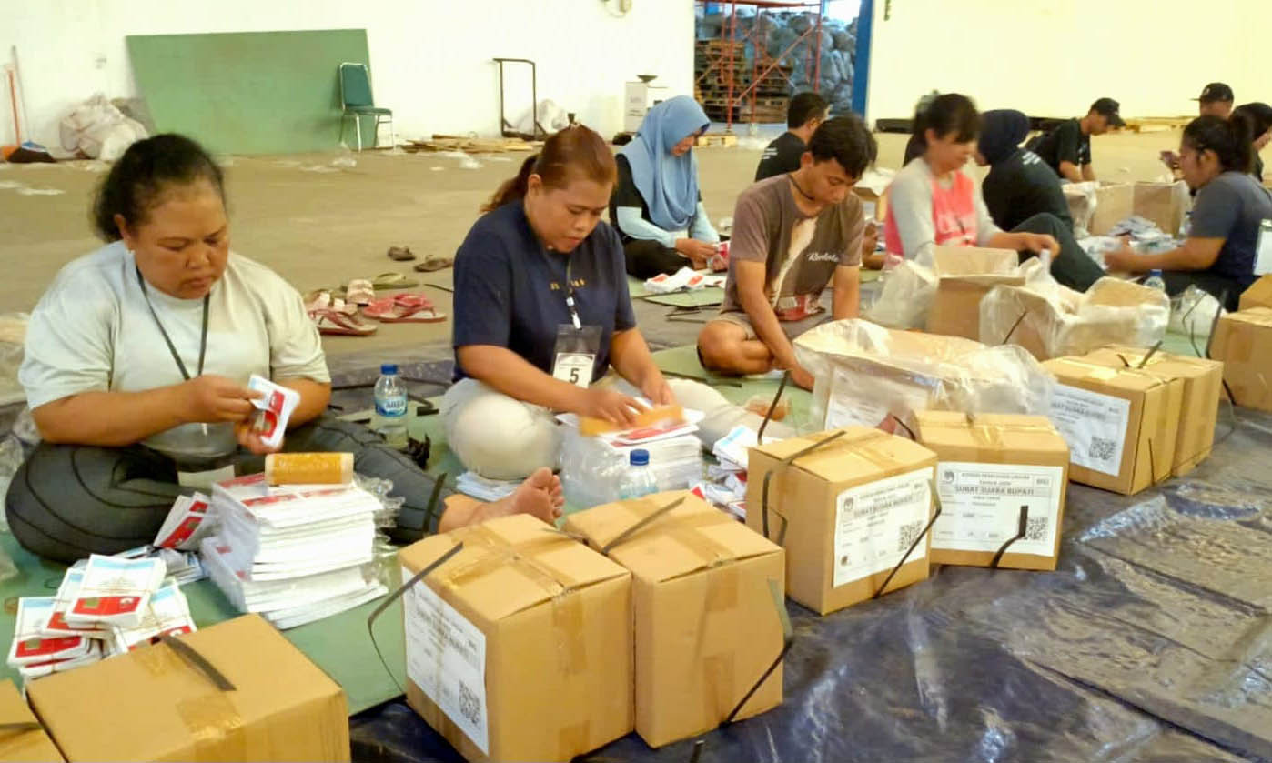 LIBATKAN ORANG LUAR: Proses pelipatan surat suara Pilbup Pasuruan di gudang logistic yang ada di Kelurahan Pohjentrek. Proses ini diawasi ketat.
