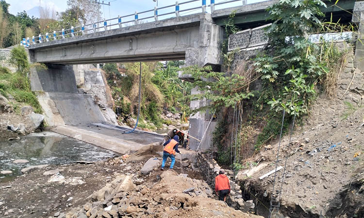 DIPACU: Pekerja tampak sibuk menggarap rehabilitasi Jembatan Ngipik yang tengah diburu waktu. Proyek tersebut, sudah harus terselesaikan awal Desember 2024.