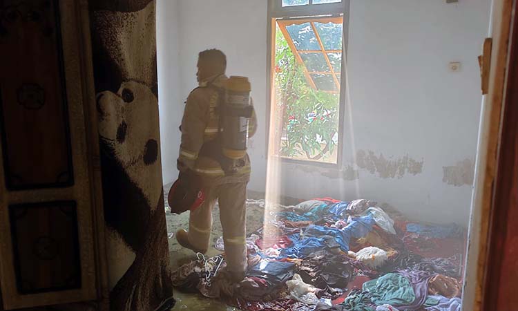 AMUK SI JAGO MERAH: Tim Damkar saat berupaya memadamkan api di rumah karyawati Pabrik Garmen di Mangunharjo, Probolinggo.