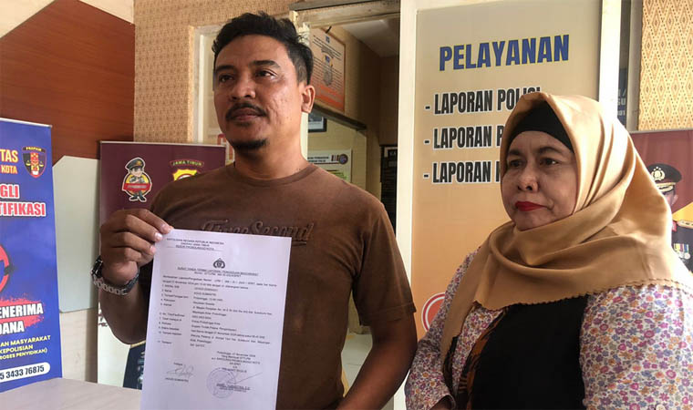 Agus Sumantri (kiri) menunjukkan bukti laporan setelah dianiaya oleh oknum polisi.