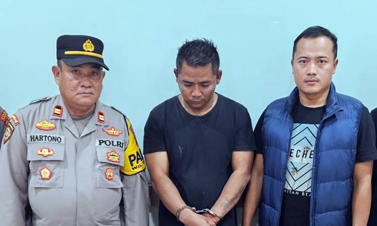 DIRINGKUS: Yosep Purnama, 45, asal Kecamatan Parigi, Kabupaten Pangandaran, Jawa Barat, diapit petugas. Ia diamankan, atas kasus perjudian online yang melilitnya.