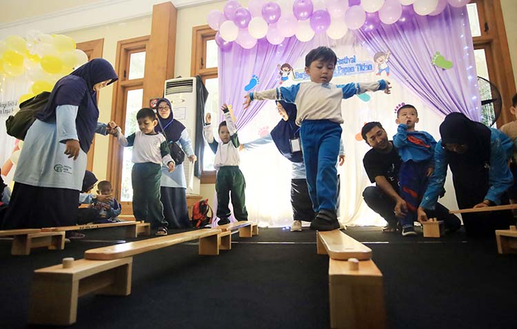 SEMANGAT: Sejumlah anak-anak hebat menunjukkan keberanian dan kemandirian meniti di atas papan kayu.